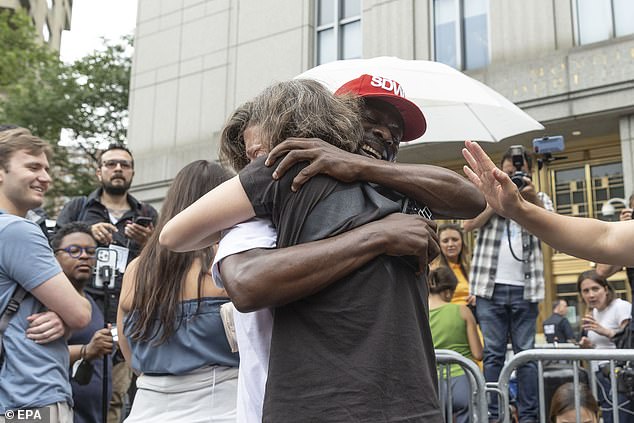 Two men are seen embracing each other following the verdict
