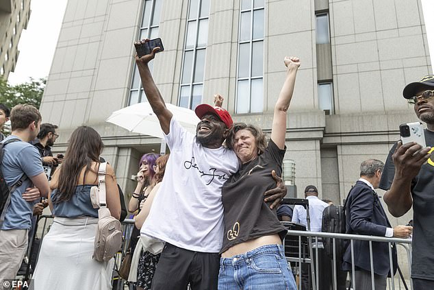 A man and woman embrace each other and hold up their arms after Diddy's verdict came in