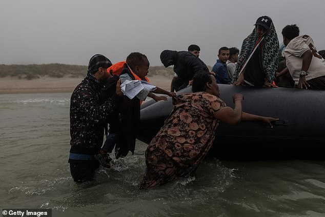 She clambers around the side as one person onboard reaches out to help - in tow, the screaming child who tugs on her top