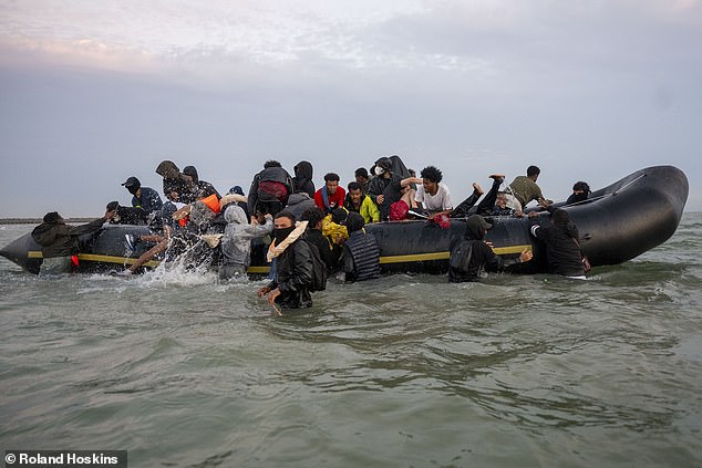 The alleged trafficker looks back as the rest of the migrants try to scramble on board