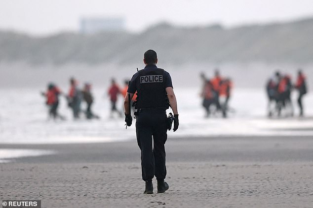 Earlier that morning, a French police officer walk was seen walking towards a group of migrants in life jackets running towards the water in the hope catching a 'taxi boat'