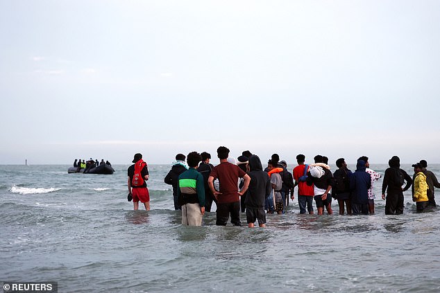 As the 'taxi-boat' dinghy pulled nearer, already half-full with previously collected passengers, the migrants waded into the water ready to climb aboard