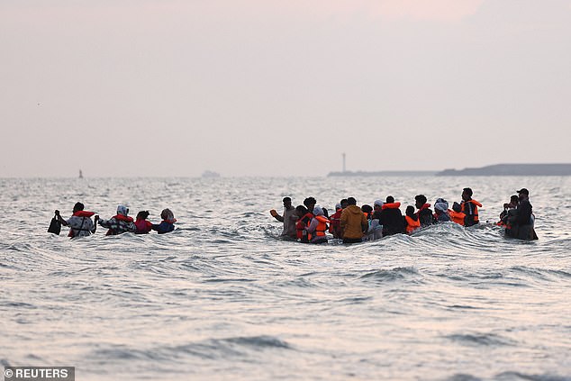 The migrants wade up to their chest to try and climb aboard