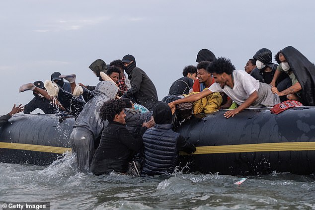 Migrants on board were seen helping people in the water as they tried to haul themselves onto the boat