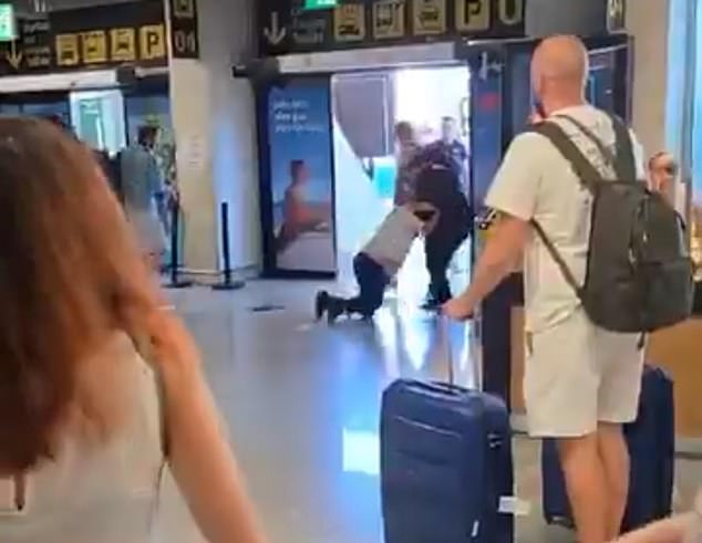 A video shows the pair exchanging punches and wrestling each other in front of confused passengers on Saturday morning