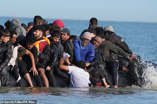 A whopping 3.4 per cent - one in 30 - small boat migrants end up behind bars according to the study (pictured: Migrants on a dinghy in the Channel last month)