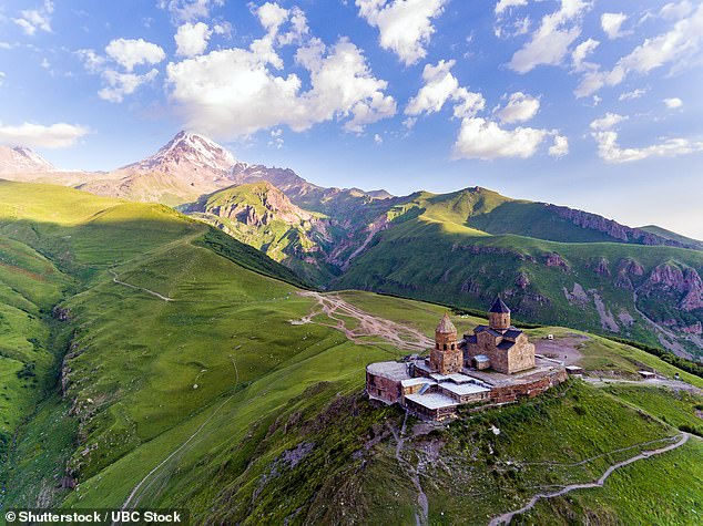 Pictured: Gergeti Trinity Church Or Tsminda Sameba - Holy Trinity Church Near Village Of Gergeti In Georgia