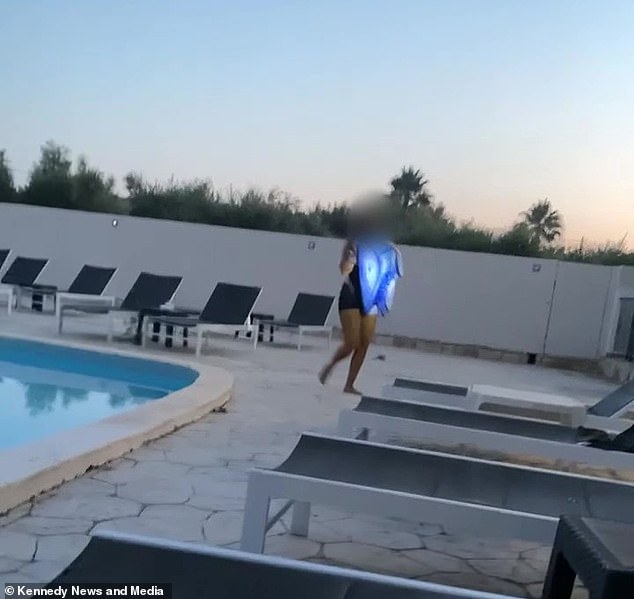 A woman is seen by the hotel pool in Zante taking a towel from a sun lounger