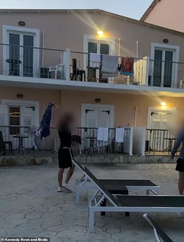 A British holiday worker is seen taking a towel from a sun-lounger in a hilarious act of revenge against 'selfish' tourists