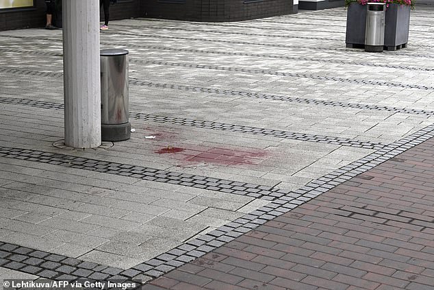 Images of the scene show blood stains on the pavement