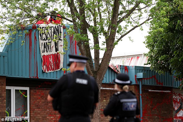 Police officers stand as protesters from "Palestine Action" demonstrate on the roof of Guardtech Group in Brandon, Suffolk, Britain, July 1, 2025