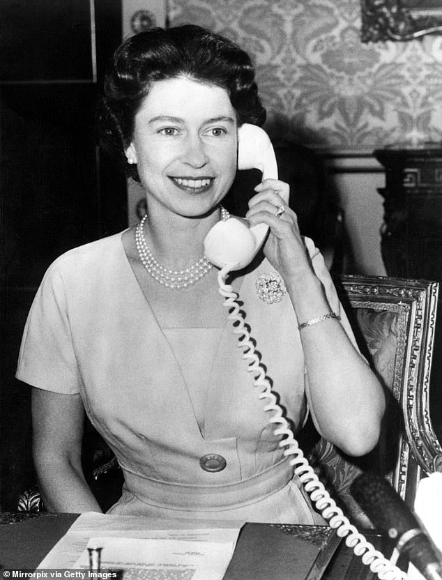 Queen Elizabeth II is pictured speaking to the Prime Minister of Canada, Mr Diefenbaker, from Buckingham Palace over the telephone in December 1961