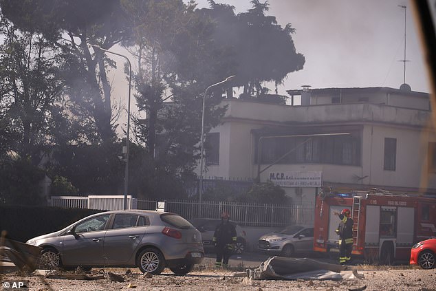 Firefighters work as smoke rises after a gas station exploded on the outskirts of Rome, Friday, July 4, 2025