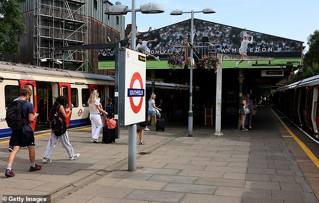 People queue to enter Southfields London Underground station after Wimbledon on Tuesday