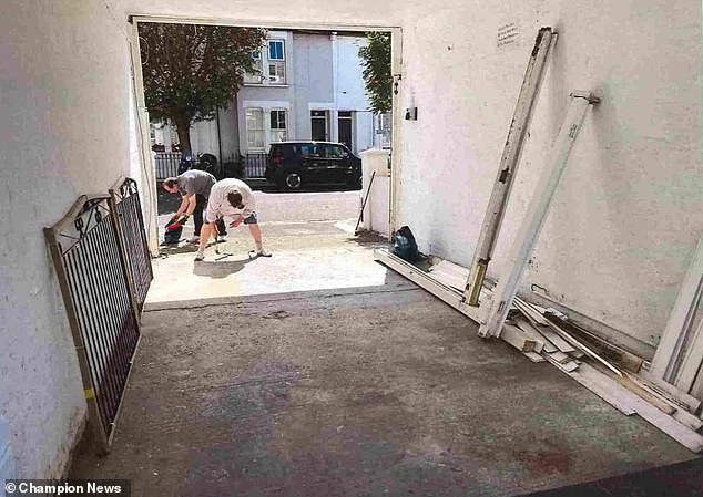 Pictured: Mr Udal (back) and a helper in the act of destroying his neighbours' gate