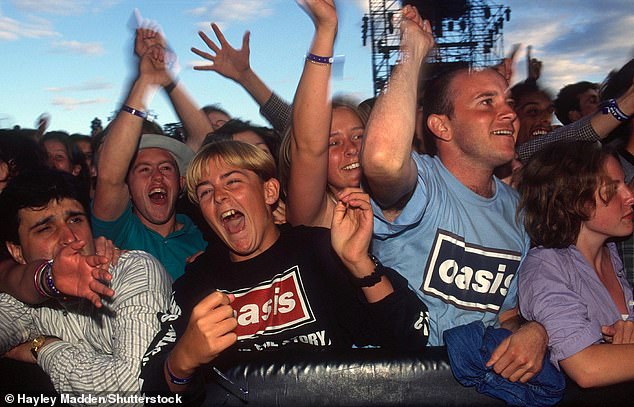 One image captures the true essence of Oasis mania in the 90's as fans cheer on their idols during the 1996 Knebworth concert