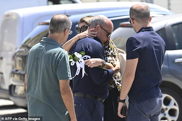 The father of Liverpool's Portuguese forward Diogo Jota and his brother Andre Silva is conforted by a woman during the wake for his two sons in Gondomar
