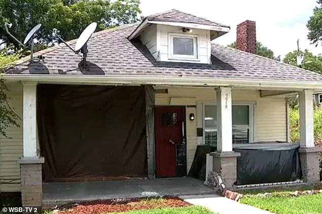 'The car just turned and crashed into the house. Actually the double windows were right here,' Chris Walker, who was housesitting the property for its landlord, told WSBTV; the house is pictured with a tarp covering where Patton's car crashed into the home