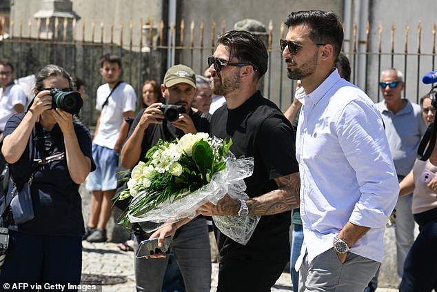 Portuguese football player and friend Jota Silva (C) who plays for the Premier League club Nottingham Forest, arrives with flowers at the chapel