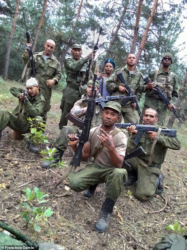 Instead Francisco (pictured crouching on the far right with no hat) alleges he was forcibly enlisted into the Russian army against his will