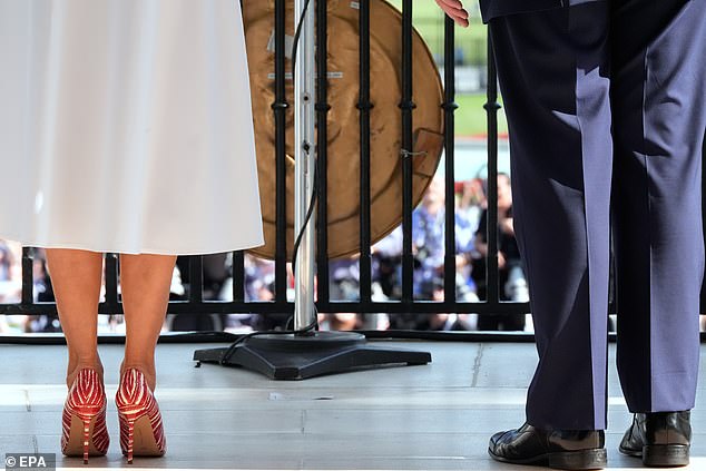 First lady Melania Trump (left) was sporting red and white stiletto heels as she and President Donald Trump (right) watched military flyovers and marked the Fourth of July from the Truman Balcony Friday