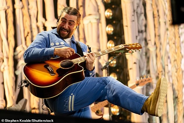 Noah cut a casual figure in a blue ensemble and brown boots as he played guitar for his fans