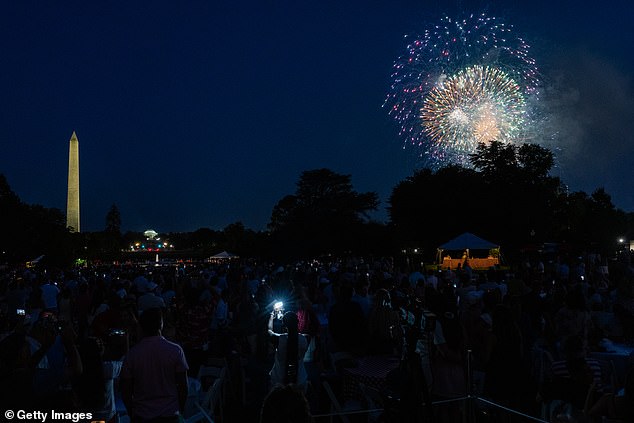 Fireworks can be seen over the National Mall with the Washington Monument in the background from the White House's South Lawn, where the Trumps invited military members and their families