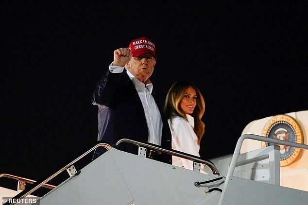 President Donald Trump (left) raises his first as he boards Air Force One alongside first lady Melania Trump (right) after spending the day celebrating the Fourth of July in Washington, D.C. The first couple was headed to their Bedminster, New Jersey golf resort