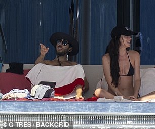 The pair strolled side-by-side as Dakota showcased her toned figure in a white bikini top as well as a floral skirt