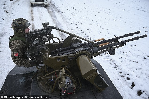 A Ukrainian serviceman of the mobile air defense unit sits behind an anti-UAV machine gun tracking Russian drones in the sky during a patrol on November 29, 2024 in Chernihiv Oblast, Ukraine