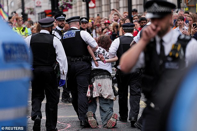 Police officers detain a "Youth Demand" activist, on the day of the 2025 Pride Parade in London