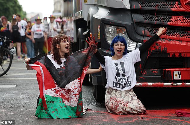 Pro-Palestine protesters from Youth Demand throw red paint and glue themselves to the lead float