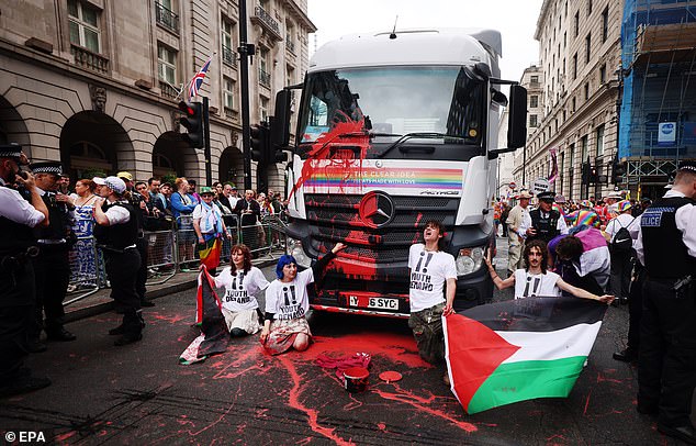 Pro-Palestine protesters from Youth Demand throw red paint and glue themselves to the lead float during the annual Pride parade in London