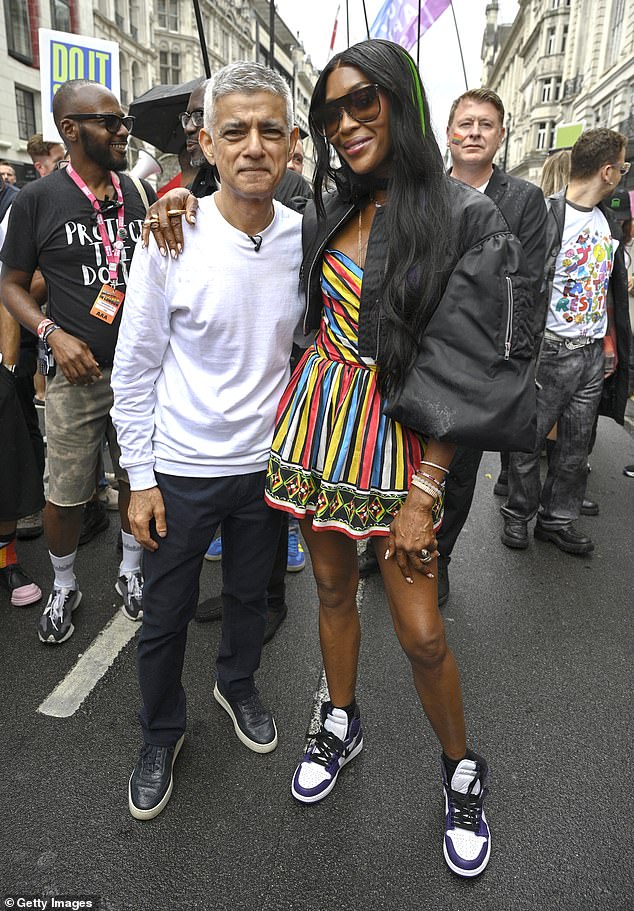 Naomi, 55, embraced colour as she stunned revelers in a sleeveless fitted bodice style mini dress, wearing chunky shades (pictured with Mayor of London Sadiq Khan)