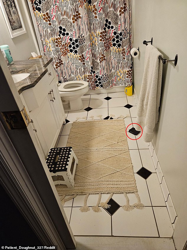 The wallet is lying diagonally near the bottom right corner of the image, perfectly camouflaged against one of the black diamond-shaped tiles on the floor