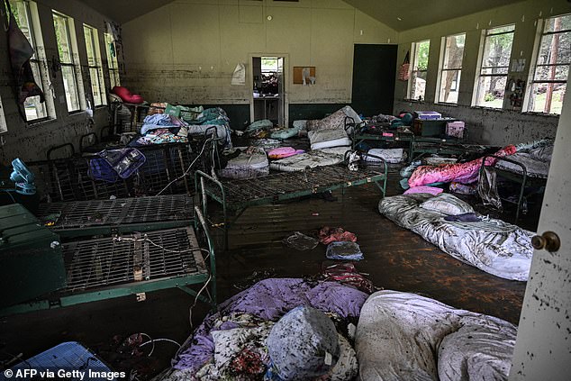 The girls' sodden beds and belongings were seen covered in river water following the decimation