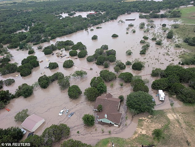 The flooding, triggered by heavy rains overnight, left little time for families along the river to react. Pictured: Houses and cars are partially submerged in flood waters in an aerial view near Kerrville, Texas on July 4, 2025
