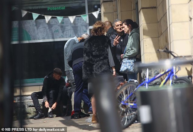 A man appears to be negotiating with a woman in a doorway in the Rawson Square area of Bradford