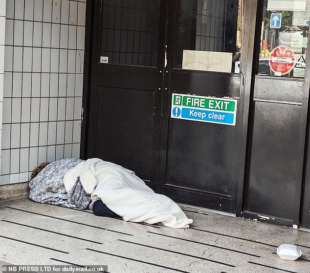 A homeless person sleeps in a doorway with only two blankets for comfort in Rawson Square