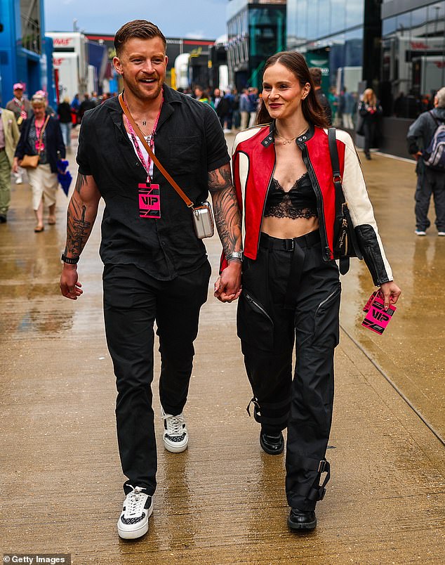 In keeping with the occasion, Holly rounded off her look with a red and white leather racing jacket and zipped cargo pants while walking hand-in-hand with former Olympian Peaty