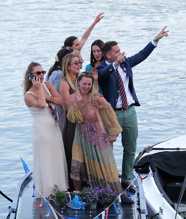 People dressed in glamorous outfits stood and danced on boats that were moored on the Thames