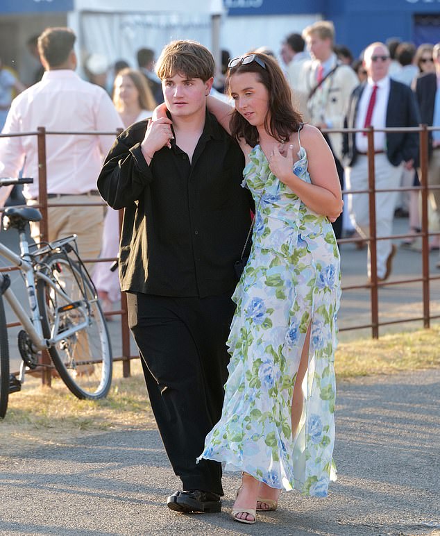 One Henley Regatta attendee looks worse for wear as she dangles her arm over a man's shoulder