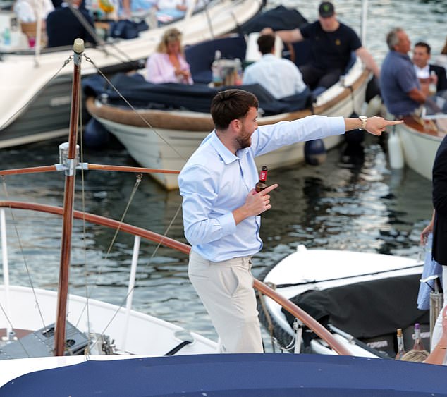 A man holds a bottle of beer and points his finger as the partying continued on the Thames last night