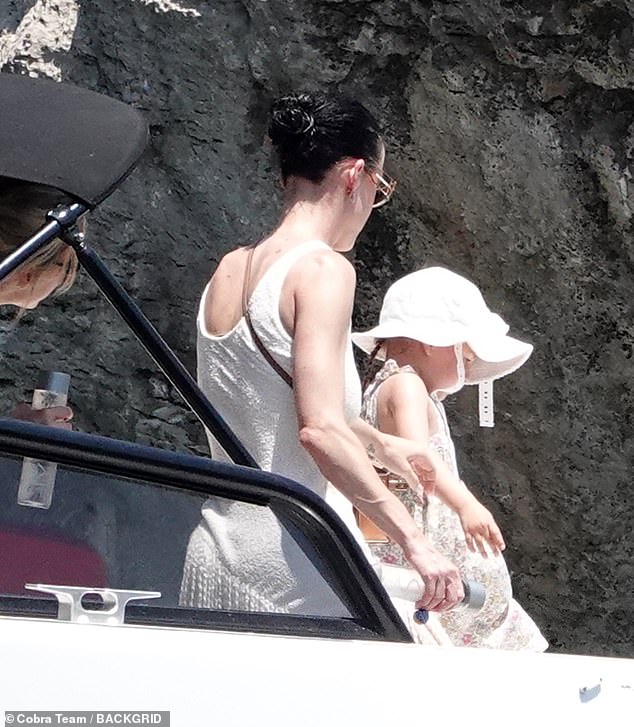 Her mini-me daughter coordinated with her in a floral dress and white sun hat