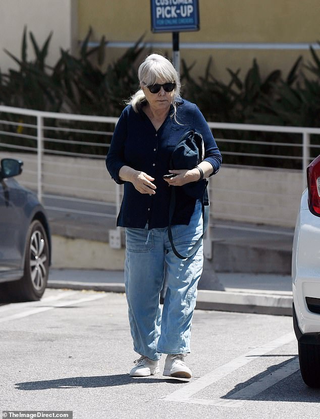 On her outing, she wore a navy blue button-up quarter-sleeve shirt, a pair of hip and slightly baggy light-wash denim jeans with a pair of white sneakers