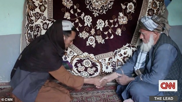 Parwana's buyer Qorban (right), who only has one name, arrived at the family's home with the payment to give her father Abdul (left)
