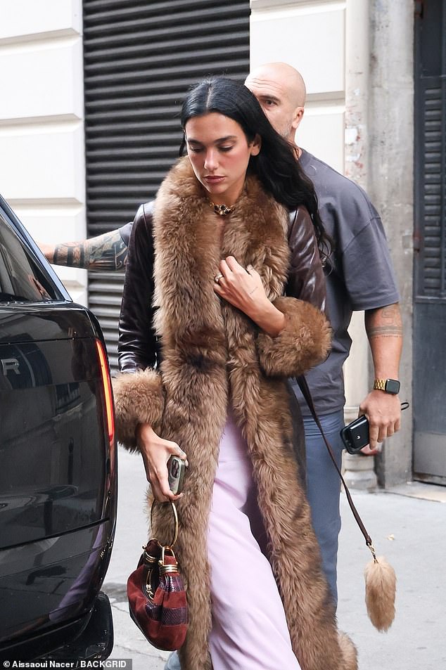 Dua was effortlessly stylish in the £2K light pink silk midi-dress which boasted lace detailing and she layered it with a long £6K leather coat