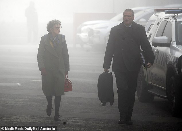 Detective Stephen Eppingstall (right) with prosecutor Dr Nanette Rogers walk through the fog on their way to the Latrobe Valley Law Courts on June 12