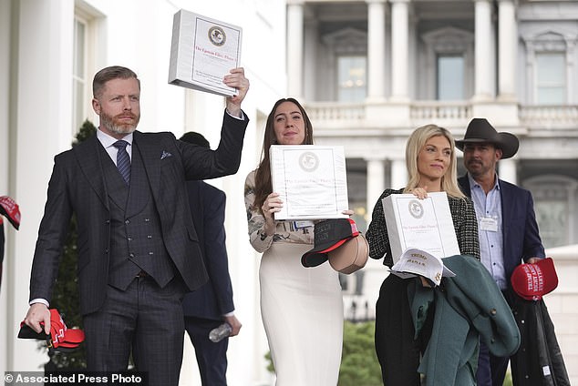 Conservative political commentator Rogan O'Handley, also known as DC Draino, from left, social media content creator Chaya Raichik and conservative political commentator Liz Wheeler hold up binders with a cover titled "The Epstein Files: Phase 1," with Jack Posobiec at the White House