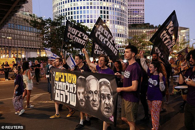 Demonstrators hold a banner featuring images of Israeli Prime Minister Benjamin Netanyahu, Finance Minister Bezalel Smotrich and National Security Minister Itamar Ben-Gvir, during a protest to demand the immediate release of hostages held in Gaza, in Tel Aviv, July 5, 2025